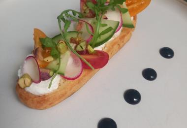 Éclair salé chèvre miel, pistaches concassées, crudités et vinaigrette balsamiqu Le gam